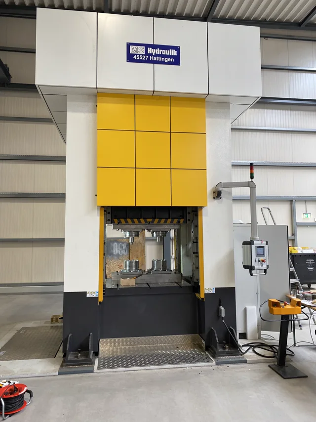 Große Hydraulikpresse mit gelbem Pressenstößel